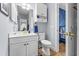 Bright bathroom with a white vanity, sink, and toilet, adjacent to a bedroom with navy blue accents at 4787 Wild Iris Dr. # 101, Myrtle Beach, SC 29577