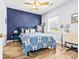 Comfortable bedroom with a custom blue accent wall, ceiling fan, and bright natural light at 4787 Wild Iris Dr. # 101, Myrtle Beach, SC 29577