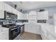 Bright kitchen featuring white cabinets, stainless steel appliances, tile backsplash, and a large arched window at 4787 Wild Iris Dr. # 101, Myrtle Beach, SC 29577