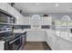 Bright kitchen featuring white cabinets, stainless steel appliances, tile backsplash, and a large arched window at 4787 Wild Iris Dr. # 101, Myrtle Beach, SC 29577
