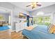 Serene main bedroom with blue bedding, wood floors, large windows, and a view of the lush backyard at 4787 Wild Iris Dr. # 101, Myrtle Beach, SC 29577