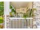 Well-maintained covered patio with wicker furniture, stone pillars, and a tranquil garden view at 4787 Wild Iris Dr. # 101, Myrtle Beach, SC 29577