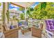 Relaxing covered porch with wicker furniture, throw pillows, and lush green landscaping at 4787 Wild Iris Dr. # 101, Myrtle Beach, SC 29577