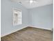 Bedroom with wood floors, large window, and light blue walls at 4878 Dahlia Ct. # 104, Myrtle Beach, SC 29577