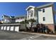 Two story condo building with garages, brick accents, balconies and palm trees at 4878 Dahlia Ct. # 104, Myrtle Beach, SC 29577