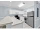 Bright kitchen features white cabinets, stainless steel appliances, and tile flooring at 4878 Dahlia Ct. # 104, Myrtle Beach, SC 29577