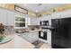 Well-lit kitchen with white cabinetry, black appliances, and a mosaic backsplash at 503 20Th Ave. N # 19-C, North Myrtle Beach, SC 29582
