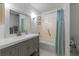 Bright bathroom features a gray vanity, a mirror and a shower with a blue shower curtain at 513 38Th Ave. N # 202, Myrtle Beach, SC 29577
