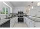 A well-lit kitchen with white cabinetry, granite countertops, stainless steel appliances, and a view to the outside at 513 38Th Ave. N # 202, Myrtle Beach, SC 29577