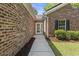Brick home walkway leading to a white front door, complemented by manicured landscaping at 561 Bucks Trail, Longs, SC 29568