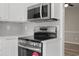 Close-up of kitchen stove with stainless steel microwave and white countertops at 561 Bucks Trail, Longs, SC 29568