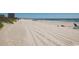 Expansive beach view showing the shoreline, clear sky, and distant buildings; perfect for a serene getaway at 6001-1783 S Kings Hwy., Myrtle Beach, SC 29575
