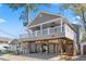 Inviting beach house with a raised foundation, large porch with fans, and cozy hammock under the house at 6001-1783 S Kings Hwy., Myrtle Beach, SC 29575