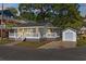 Charming home with white siding, a covered porch, and a detached garage, bathed in soft evening light at 6001-7035 S Kings Hwy., Myrtle Beach, SC 29575