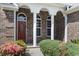 Charming front entrance with brick facade, white pillars, and a decorative red door, creating an inviting curb appeal at 736 Lalton Dr., Conway, SC 29526