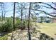 Lush backyard with mature trees and a view of neighboring homes, blending nature and neighborhood charm at 742 Tall Oaks Ct., Myrtle Beach, SC 29588