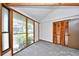 Well-lit bedroom with a wall of windows, wood trim, neutral carpet, and a closet with folding doors at 742 Tall Oaks Ct., Myrtle Beach, SC 29588