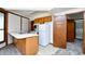 This kitchen includes white appliances, wood cabinets, a peninsula, and opens up to another room at 742 Tall Oaks Ct., Myrtle Beach, SC 29588
