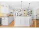 Bright kitchen features white cabinetry, granite countertops, and an island with bar seating at 8231 Forest Lake Dr., Conway, SC 29526