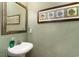 Cozy powder room features a pedestal sink, decorative mirror, and charming coastal artwork at 830 Howard Ave. # D, Myrtle Beach, SC 29577