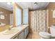 Compact bathroom featuring a double sink vanity, updated toilet, and a shower with patterned curtain at 976 South Marlin Circle, Murrells Inlet, SC 29576