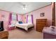 Stylish bedroom featuring pink walls, two windows, a bed with neutral bedding, and carpet floors at 976 South Marlin Circle, Murrells Inlet, SC 29576