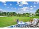 Serene backyard featuring a tranquil lake view, well-maintained lawn, and a charming patio set at 1001 Harvest View Ave., Conway, SC 29527