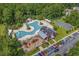 Aerial view of the community pool, playground, barn-style clubhouse and basketball court nestled among mature trees at 1004 Harvester Circle # 1004, Myrtle Beach, SC 29579