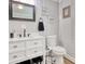 Bathroom offers a neutral palette with wainscoting, modern fixtures, and functional storage solutions for a serene retreat at 1028 1St Ave. S, North Myrtle Beach, SC 29582