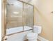 Bathroom featuring sliding glass shower doors with a white toilet and tiles at 106 Birch N Coppice Dr. # 2, Surfside Beach, SC 29575