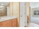 Spacious bathroom with wood cabinets and a shower door beyond at 106 Birch N Coppice Dr. # 2, Surfside Beach, SC 29575