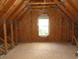 Unfinished attic with visible wooden framing and a window for natural light at 108 Pickerel Blvd., Longs, SC 29568