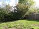 Lush backyard with green grass, mature trees, and a wooden fence at 108 Pickerel Blvd., Longs, SC 29568