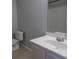 Bathroom featuring a sink with vanity, toilet, and a glimpse of the shower with tile surround at 108 Pickerel Blvd., Longs, SC 29568