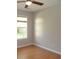 A light-filled bedroom featuring hardwood floors, a ceiling fan, and a window overlooking the yard at 108 Pickerel Blvd., Longs, SC 29568