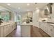 Modern kitchen with white cabinetry, island with white countertop, stainless steel appliances, and access to the backyard at 1118 Laconic Dr., Myrtle Beach, SC 29588