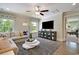 Cozy living room features hardwood floors, a sectional sofa, entertainment center, and bright windows at 1118 Laconic Dr., Myrtle Beach, SC 29588