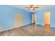 Bright bedroom featuring a ceiling fan, wood-look flooring, and a doorway that opens into another room at 112 Boxwood Ln., Conway, SC 29526