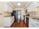 Galley kitchen features stainless steel appliances, granite counters, white cabinets, and access to the rear of the house at 112 Boxwood Ln., Conway, SC 29526