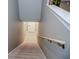 Carpeted staircase with wooden handrail leading to a tiled hallway with a white door at 1131 Camellia Dr., Surfside Beach, SC 29575