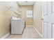 Functional laundry room with washer, dryer, storage shelf, and tiled floors at 119 Berry Tree Dr., Pawleys Island, SC 29585
