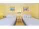 Bright bedroom featuring two beds, light yellow walls and beach-themed decor at 1207 S Ocean Blvd. S # 50910, Myrtle Beach, SC 29577