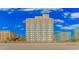Exterior shot of a beachfront condominium building, showcasing balconies and ocean views under a bright, blue sky at 1207 S Ocean Blvd. S # 50910, Myrtle Beach, SC 29577