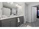 Spacious bathroom with a double vanity, gray cabinets, framed mirrors, and a walk-in shower behind the door at 136 Queens Cove Place # B, Myrtle Beach, SC 29579