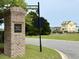 Community sign for Queen's Cove Garden Homes is on Castle Pinckney Dr, set amidst lush landscaping and attractive neighborhood architecture at 136 Queens Cove Place # B, Myrtle Beach, SC 29579