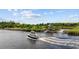 A boat driving on the intercoastal waterway near a white gazebo and well-maintained landscaping at 136 Queens Cove Place # B, Myrtle Beach, SC 29579