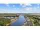 Scenic aerial view of a waterway lined with lush trees and residential buildings under a blue sky with clouds at 1514 Lanterns Rest Rd. # 304, Myrtle Beach, SC 29579