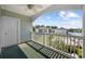 Balcony with a ceiling fan overlooks an in-ground pool and nearby buildings and waterway at 1514 Lanterns Rest Rd. # 304, Myrtle Beach, SC 29579