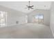 Spacious carpeted living room featuring a ceiling fan, a sliding glass door to a porch, and neutral decor at 1514 Lanterns Rest Rd. # 304, Myrtle Beach, SC 29579