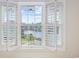 Charming view of the lake through bright, white shuttered windows in a well lit living space at 1514 Lanterns Rest Rd. # 304, Myrtle Beach, SC 29579